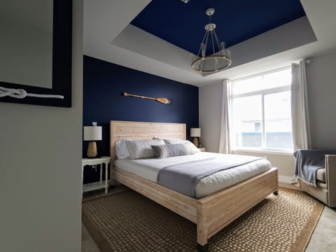 Second king bedroom on opposite end of main floor. Cotton Oeko-Tex linens, TV, coastal design. Main bathroom across the hall.