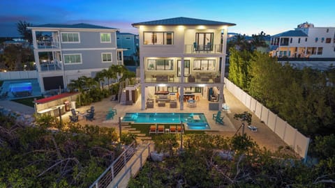 Three waterfront stories with a heated pool, outdoor lounge, and balconies on every level.