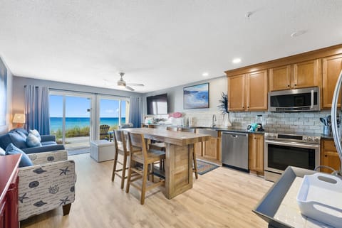 Your open-concept kitchen flows into a cozy living area where stunning ocean views create the perfect backdrop for cooking and relaxing together.