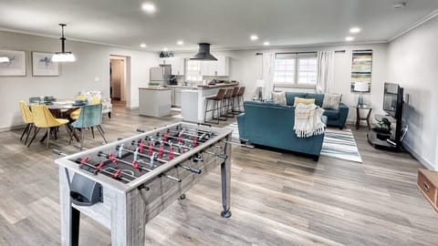 Open living area with foosball table, sectional seating, and smart TV.