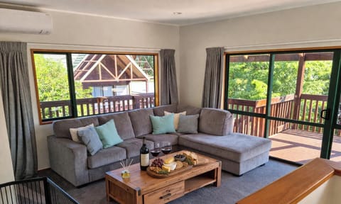 Spacious lounge with large deck access and gorgeous green views -  the perfect spot to unwind