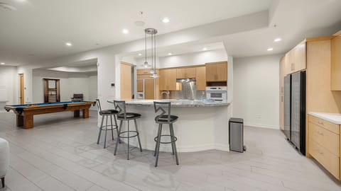 Entertainment area with wet bar, pool table, and modern design details.