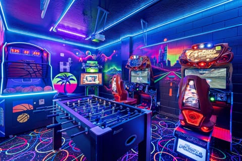 - Neon arcade game room with foosball basketball and racing games for nonstop fun  
- Colorful design and glowing décor create exciting Orlando vacation rental vibes  
- Entertainment for families kids and groups staying near Disney attractions