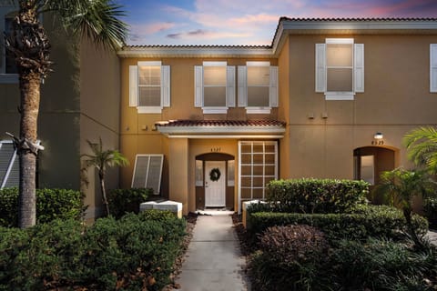 Step into a charming exterior framed by vibrant greenery, where a welcoming pathway leads to a stylish entrance. The soft glow from the windows hints at the cozy atmosphere inside, perfect for relaxing after a day of adventure.
