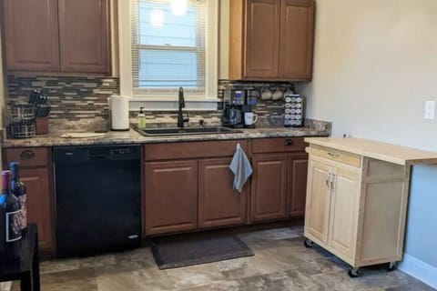 Rolling island pushed up against the wall and full view of kitchen less the appliances on the wall behind the camera