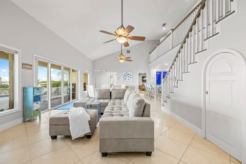 Spacious living area with vaulted ceilings and large windows overlooking the outdoor deck.