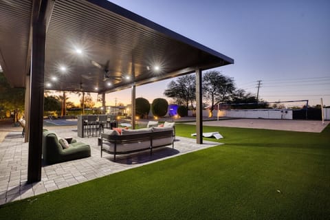 Covered patio lounge area with turf and open views of the court.
