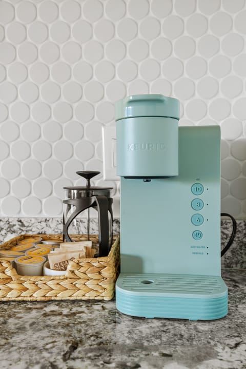 Keurig coffee maker and a selection of k-cups, individual tea bags and sugar.