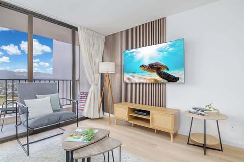 An elegant and cozy living space on the 26th floor, complete with a 65" smart TV for your entertainment, and a private balcony offering breathtaking mountain views – blending modern comfort with a tropical escape.