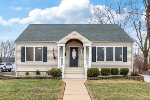 Straight-on daytime view of the beige house, covered porch, front steps, and number 906.