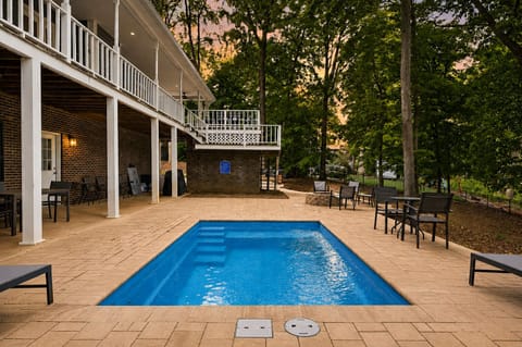 Private poolside patio with wooded views, lounge seating, and plenty of space to unwind outdoors.