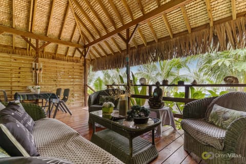 Shaded outdoor lounge with comfy seating and tropical wood design.