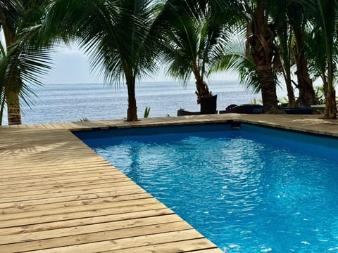 Pool on the deck at Haapiti, palms and the lagoon beyond.