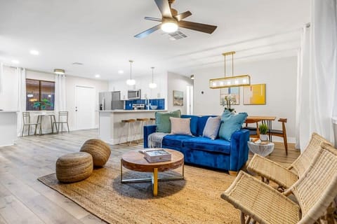Open-concept living area with a blue velvet sofa and modern kitchen.