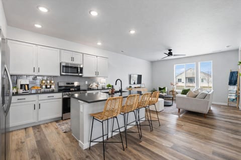 The spacious quartz island seats 4, offering a perfect spot for socializing or enjoying a meal. Sleek design and ample seating make this kitchen the heart of the home. 