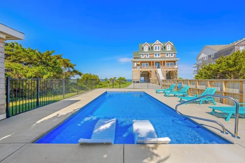 Sparkling private pool with turquoise loungers offers your perfect escape under endless blue skies, just steps from coastal beauty and beachside relaxation.
