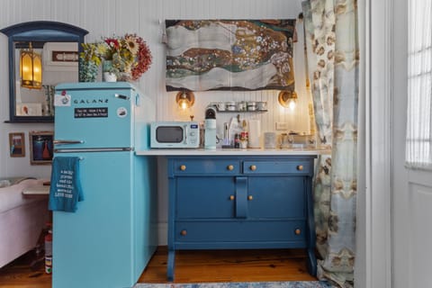 Retro fridge stocked with snacks plus coffee station and old fashioned wardrobe