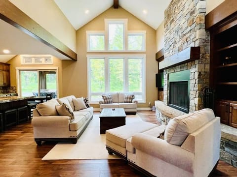 Living room with flat screen tv, fireplace and forest views