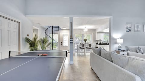 The ping pong table, strategically placed for easy access, adds a dynamic touch to your living space.