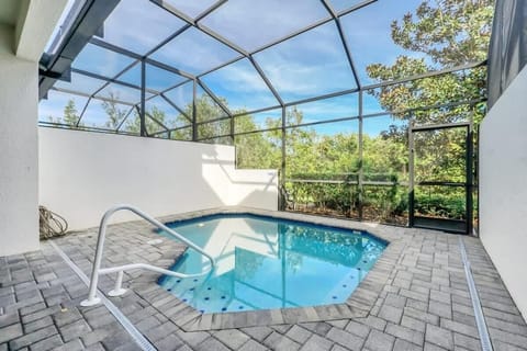 Private screened pool area with brick paver deck and garden views