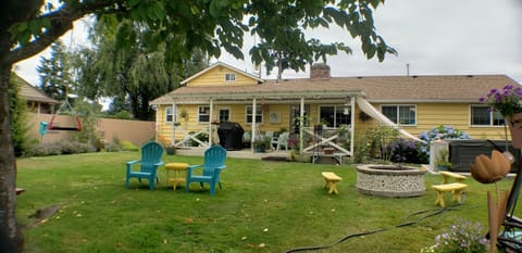Looking from backyard to house and covered patio. Entrance to unit is on left.