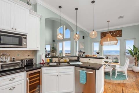 Gourmet kitchen with oversized island, granite countertops, stainless steel oven, microwave, refrigerator, and dishwasher.