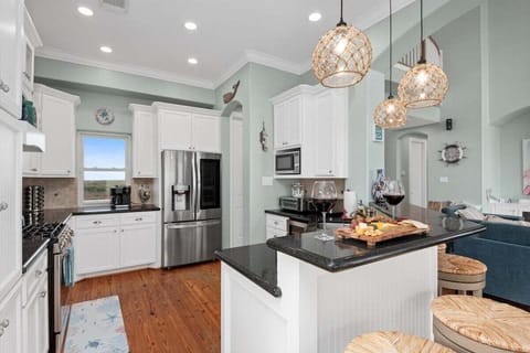 Spacious chef's kitchen with pendant lighting, custom cabinetry, and stainless steel appliances.