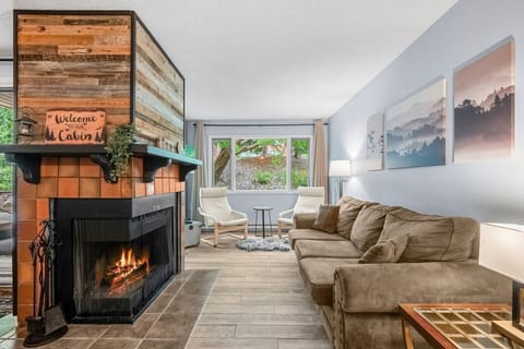 Living room with a Smart TV with cable, a decorative fireplace (glow logs only, please!) and a comfortable couch with a pull-out sleeper sofa (all linens provided.)