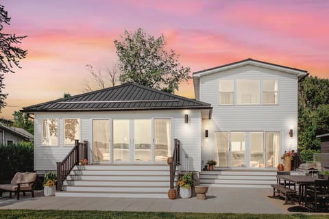 Expansive windows and two sets of sliding doors frame the lakefront view—plus a spacious patio with outdoor dining and lounge seating, perfect for soaking in every sunset and breeze.