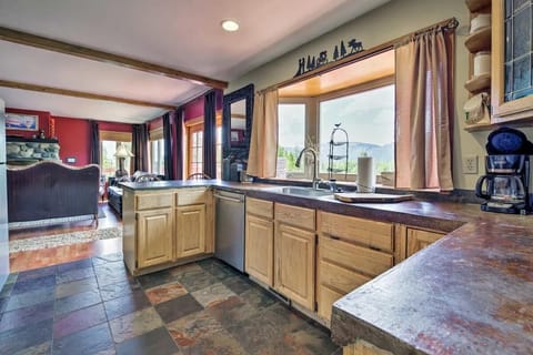Kitchen with river and mountain views, with adjacent living room and fireplace.