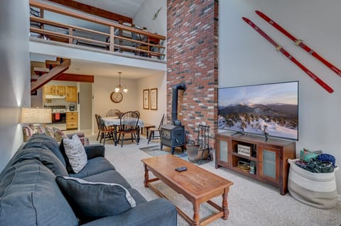 Open den area with a wood stove, large TV and a comfy sofa