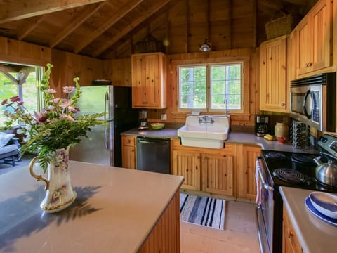 Open kitchen with large island and double french doors to screen porch w lake views