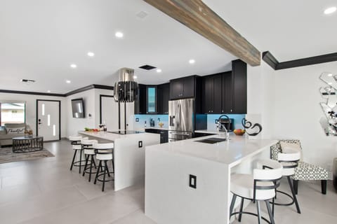 Fully equipped kitchen stocked with your basic cooking essentials, and stainless-steel appliances, bar seating, all connected to the formal and informal living areas and dining area.