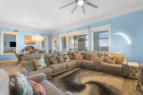 Spacious living room with a large sectional sofa and soft lighting for relaxing gatherings.