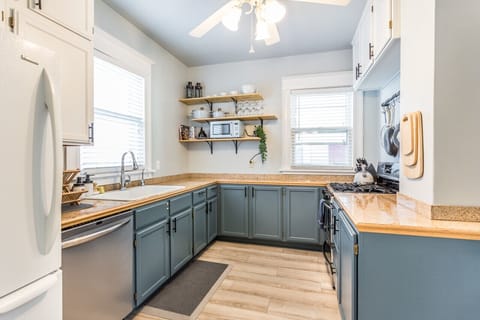A modern kitchen with ample counter space, sleek appliances, and open shelving for easy access to cooking essentials.