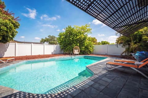 Private resort-style pool with shaded loungers and tropical backyard vibes