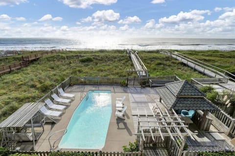 Your private oceanfront saltwater pool, tiki bar, firepit, and deck area for lounging with direct beach access.