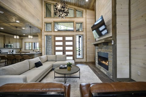 Cozy up by the crackling fireplace in this rustic living room inside a charming cabin nestled in the woods 🍂