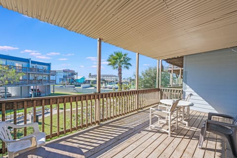 Sip your morning coffee on this spacious covered deck, where white chairs await and palm trees frame your peaceful neighborhood view.