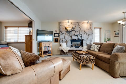 Sink into plush sofas by the crackling stone fireplace, where your cozy evenings unfold with entertainment and warmth.