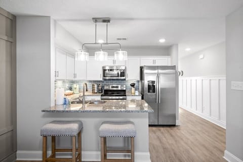 Open Kitchen with Seating and Dining Area with Stainless Steel Appliances and Kitchen Essentials