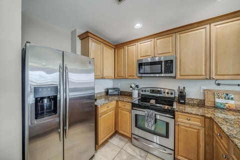 The fully equipped kitchen features granite countertops, stainless-steel appliances, and has everything you need to enjoy meals with family and friends.