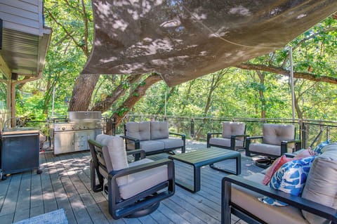 Your private covered deck offers comfortable seating and grilling station surrounded by lush trees for perfect outdoor relaxation.