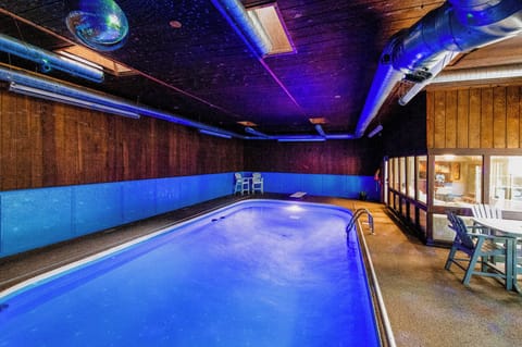 Dive into your private indoor pool sanctuary with mesmerizing blue lighting and cozy seating areas for ultimate relaxation.