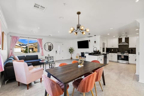 Open-concept living area w/ plush seating, large TV & seamless flow into the kitchen and dining space.