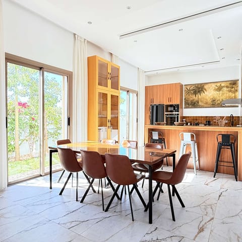 Refined dining area and fully equipped gourmet kitchen, both opening onto the garden and bathed in natural light.