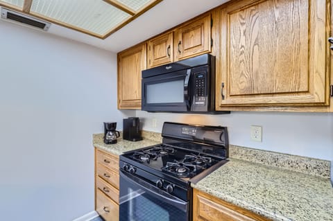 Modern culinary convenience with a sleek stove, and multiple coffee makers.