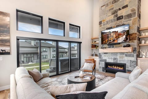Sink into plush seating by your cozy gas fireplace. Towering stone, natural light, and modern design create your perfect mountain retreat.