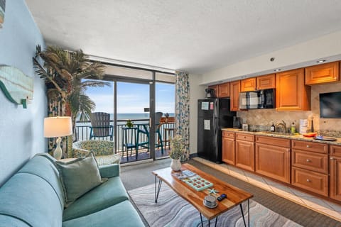 Oceanfront living space with a fully equipped kitchen and cozy couch seating that opens onto your private balcony, relax indoors or out with stunning ocean views.