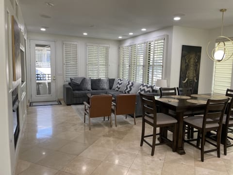 Living room with L-shaped couch, 2 leather sitting chairs, fireplace and smart TV.